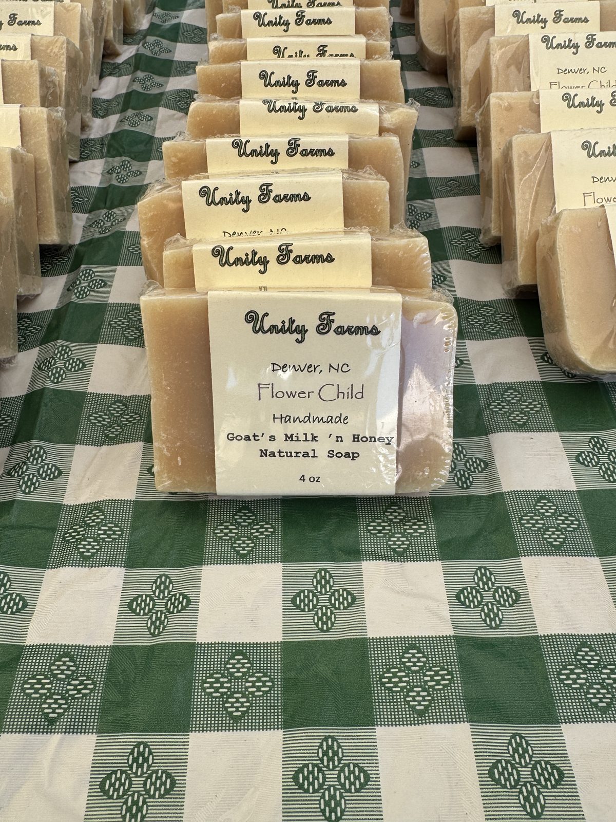 Flower Child goats milk and honey soap bars lined up at the market