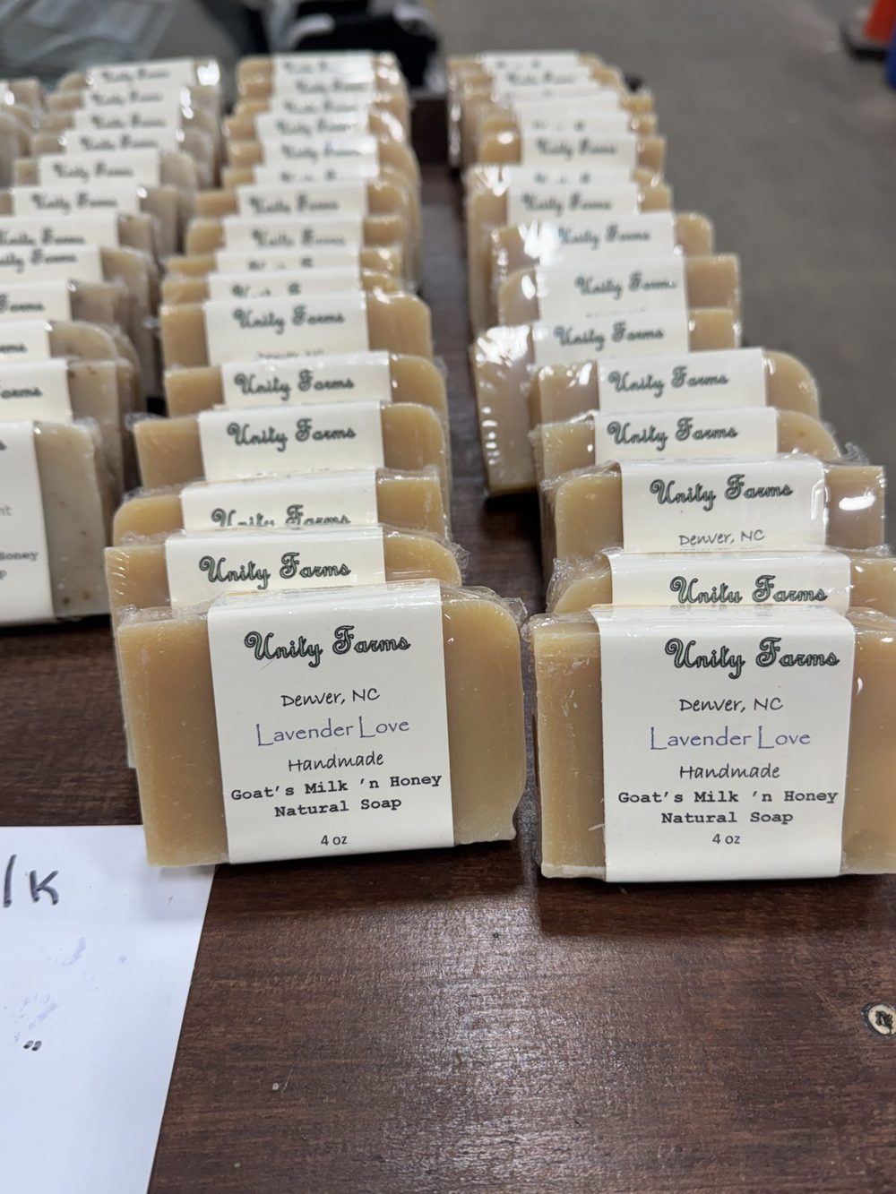 Rows of handmade Unity Farms Lavender Love goats milk and honey soap bars on a wooden table