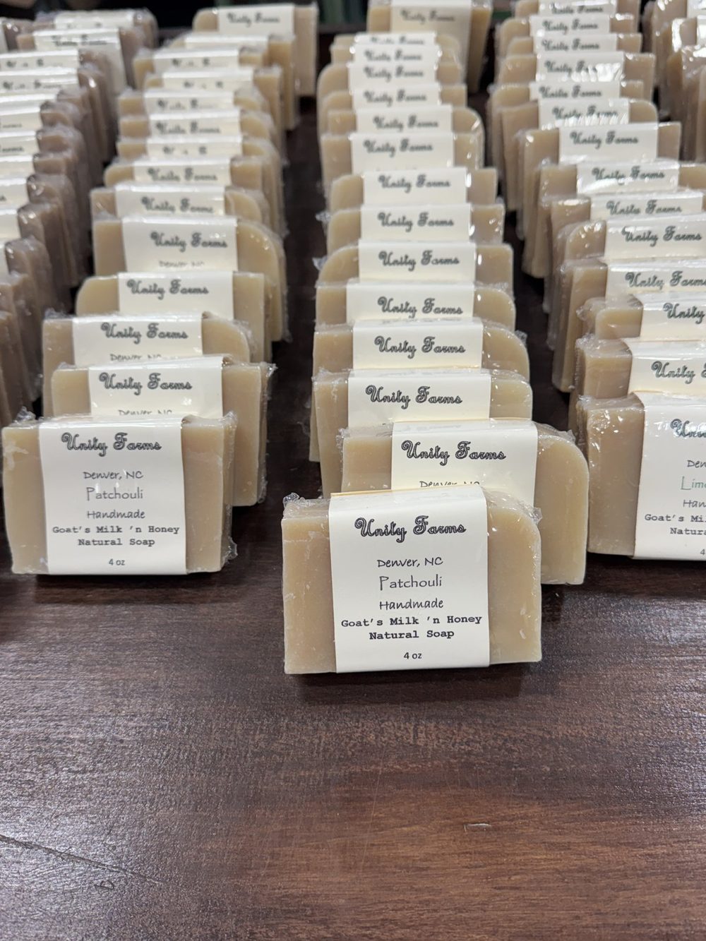 Patchouli goats milk and honey soap bars in rows on a wooden table