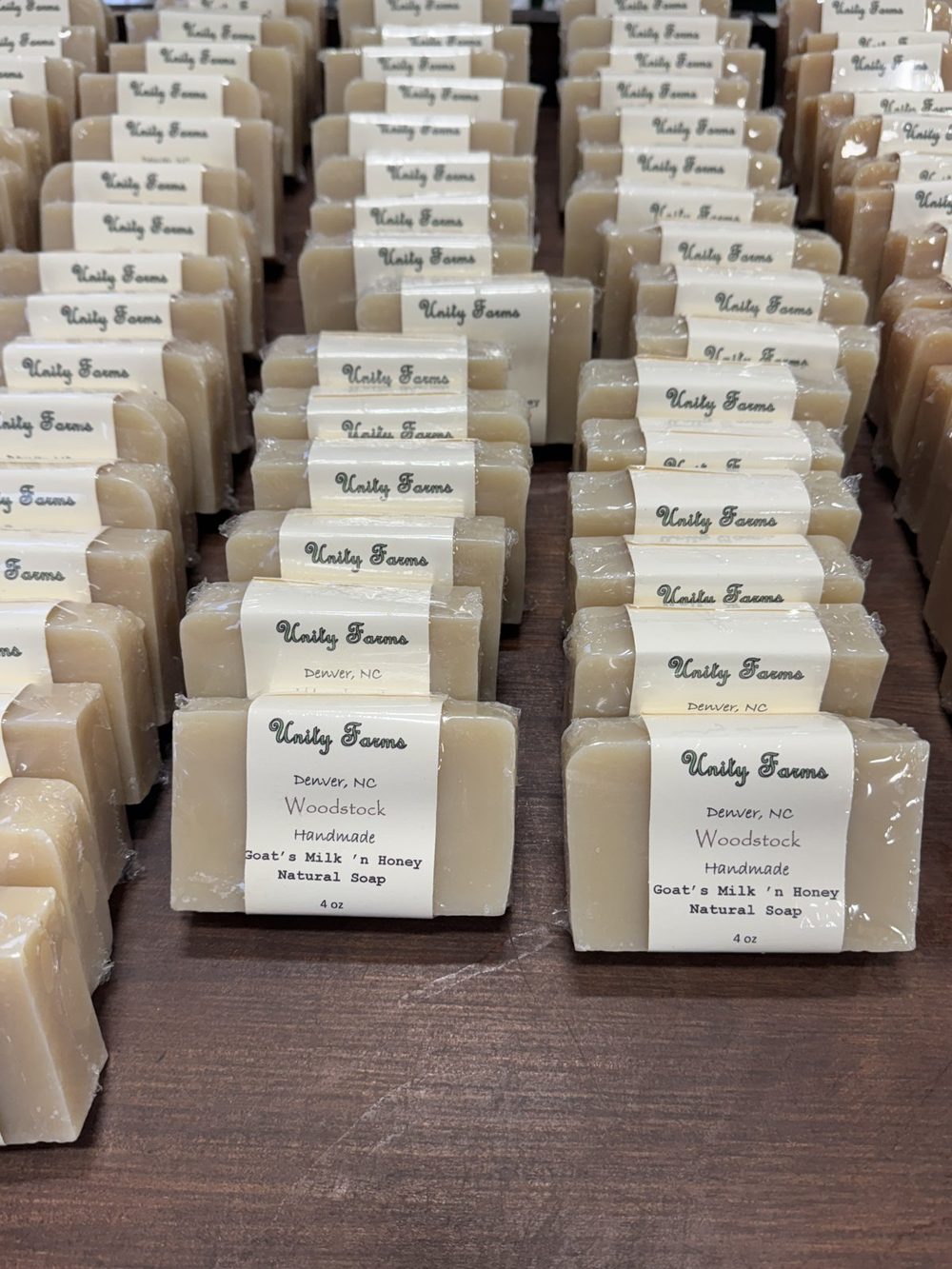 Rows of Woodstock goats milk and honey soap bars on a wooden table